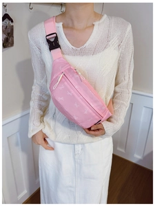 Detailed view of pink crossbody bag with white bow patterns and adjustable strap for kids