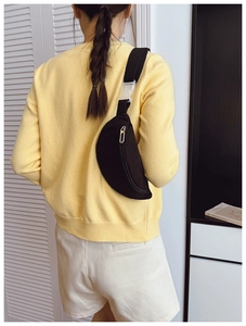 Détail du sac banane croissant en velours côtelé noir avec bandoulière réglable sur modèle
