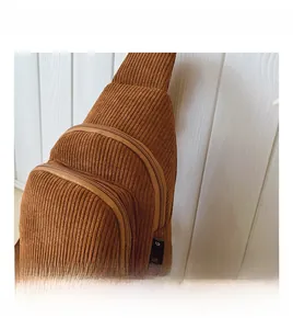 Details der braunen Kinder-Brusttasche aus Cord mit Streifenstruktur und Reißverschlüssen
