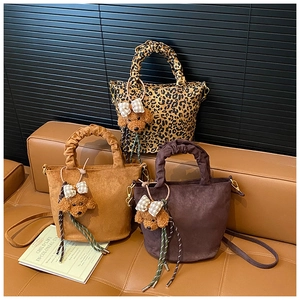 Detailed view of leopard print and suede tote bags featuring ruffled handles and teddy charms