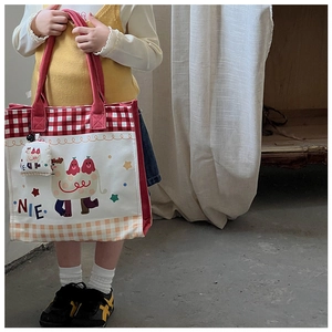 Detail shot of a kids' canvas tote bag featuring a cartoon camel and matching mini pouch