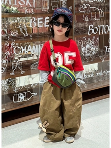 Close-up of kids' trendy red number 95 t-shirt and khaki wide-leg pants with 3D cartoon doll