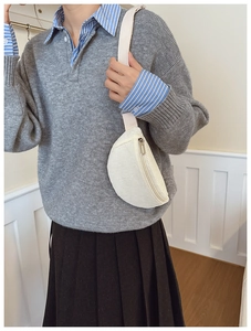 Vue détaillée de la texture en velours côtelé blanc du sac banane pour enfant avec zip