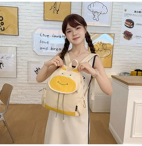 Détail du sac à dos vache mignon jaune et blanc avec oreilles 3D et visage brodé