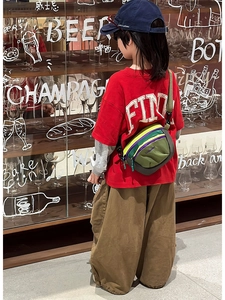 Kids colorful outdoor crossbody bag with adjustable strap worn by child model