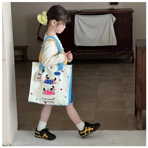 Detail of kids canvas tote bag featuring smile puppy print and matching small pouch charm