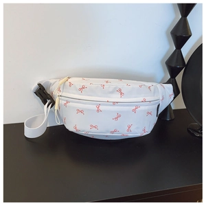 Detail of white kids waist bag with red bow print and adjustable buckle strap