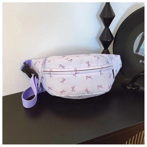 Close-up of lilac waist bag featuring purple bow patterns and durable strap with buckle