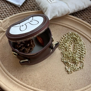 Top view of mini round brown leather crossbody bag with cartoon bunny and gold chain