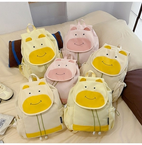 Détail des sacs à dos vache mignons en jaune et rose avec des oreilles en relief