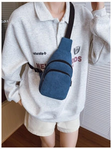Detail der blauen Kinder-Brusttasche aus Cord mit verstellbarem Gurt und Reißverschluss