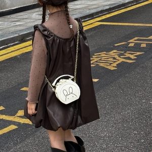 Detail of white round kid's shoulder bag with cute rabbit print and gold metal chain