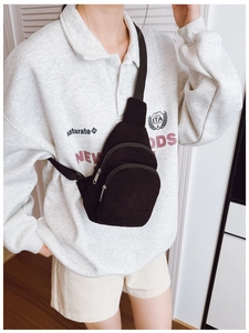 Schwarze Kinder-Brusttasche aus Cord, getragen von einem Modell in Freizeitoptik