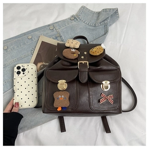 Detail of brown faux leather backpack with cartoon patches and school bag aesthetic