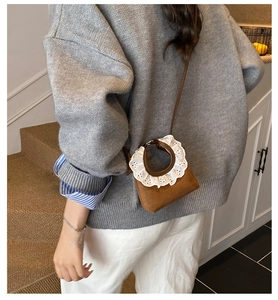 Mini sac en daim marron avec poignée en dentelle blanche porté en bandoulière