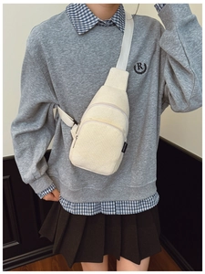 Detail der cremeweißen Cord-Brusttasche mit Reißverschluss und verstellbarem Nylon-Trageriemen