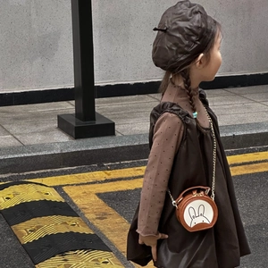 Detailed view of child's round brown rabbit crossbody bag with elegant gold chain strap