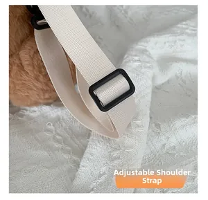 Close-up of the adjustable cream woven shoulder strap with a sturdy black adjustment buckle