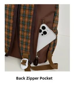 Detail of the anti-theft back zipper pocket on a brown plaid backpack for kids