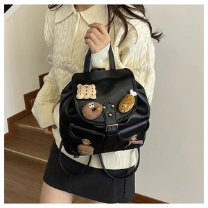 Detail of black PU leather kids backpack with cute plush patches and metal buckles