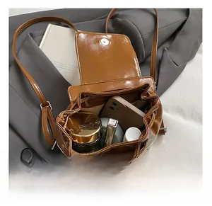 Detail view showing interior storage of brown leather backpack with skincare and makeup items