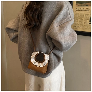 Detailed view of mini brown suede crossbody bag with vintage lace metal handle for women