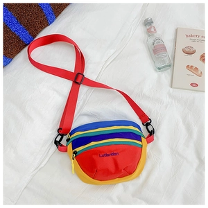 Detailed macro of colorful nylon crossbody bag with adjustable strap and zip closure