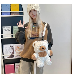 Detail of cute teddy bear plush backpack with white adjustable fabric shoulder strap