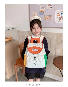 Detail view of canvas backpack featuring orange flap and colorful contrast side pockets