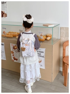 Quilted floral kids backpack featuring Merci embroidery and a brown plush bear charm
