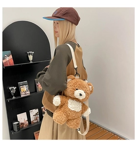 Detail of cute brown teddy bear plush backpack with white detachable strap and soft fur