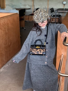 Details eines grauen Kinder-Strickoutfits mit Mini-Handtasche im Leopardenmuster