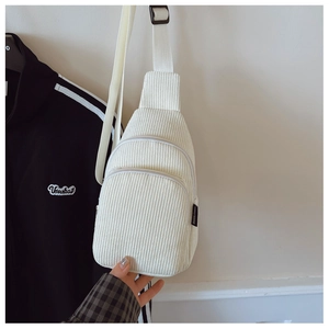 Detail der cremeweißen Kinder-Brusttasche aus Cord mit Doppelreißverschluss und Gurt