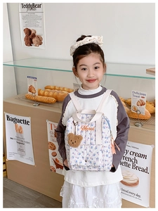 Kids quilted floral backpack with teddy bear charm and Merci embroidery in bakery scene