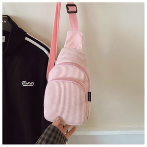 Detail der rosa Cord-Brusttasche für Kinder mit Doppelreißverschluss und Markenetikett