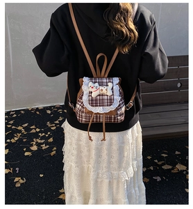 Detail of sweet lace-trimmed plaid girls backpack featuring a cute plush kitten doll