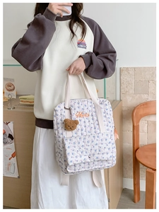 Floral quilted backpack for kids featuring Merci embroidery and a brown plush bear charm