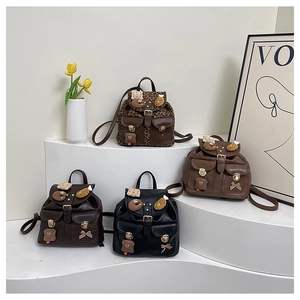 Detailed view of mini leopard print and solid backpacks with plush cartoon charms and bows