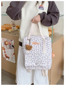 Detail of floral quilted backpack with Merci embroidery and cute teddy bear charm