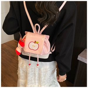 Close-up of pink PU leather toddler backpack featuring red apple embroidery and polka dots