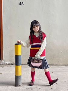 Detail einer pink-braunen Patchwork-Leder-Minihandtasche für Kinder im modischen Outfit