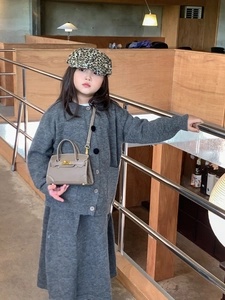Mini handbag with metal clasp and thin strap shown in a minimalist indoor setting