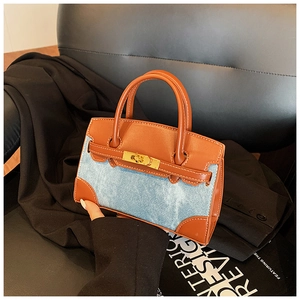 Detail der Mini-Handtasche in Color-Block-Optik aus Denim und braunem Leder auf Anzug
