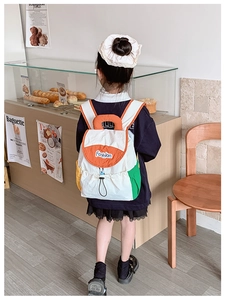 Close-up of a colorful children's backpack with drawstring and flap closure in a bakery