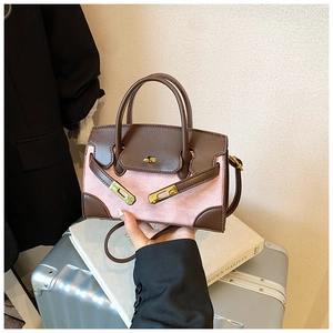 Nahaufnahme der zweifarbigen Handtasche aus rosa Stoff und braunem Leder mit Metallverschluss