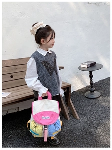 Close-up of kids multicolor backpack featuring fashion patch and adjustable buckle straps