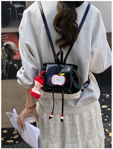 Detail of cute polka dot backpack with apple embroidery and plush charm pendant