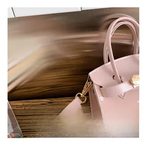 Detail view of the golden metal hook and detachable strap on pink polka dot kids handbag