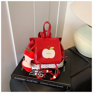 Detail of red apple-themed kid backpack with sequins and polka dot fabric base