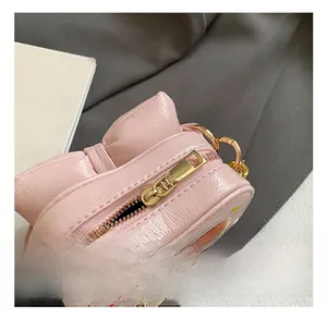 Détail du sac rose pour fille avec grand nœud et finitions en métal doré brillant
